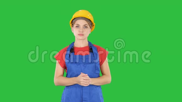 年轻的建筑工人妇女展示产品她的手从她的两侧在绿色屏幕铬键视频的预览图