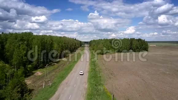 白色汽车在旧电线附近的灰色道路上行驶视频的预览图