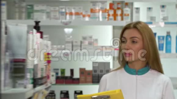 年轻的女药剂师走在药店里在清单上检查产品视频的预览图