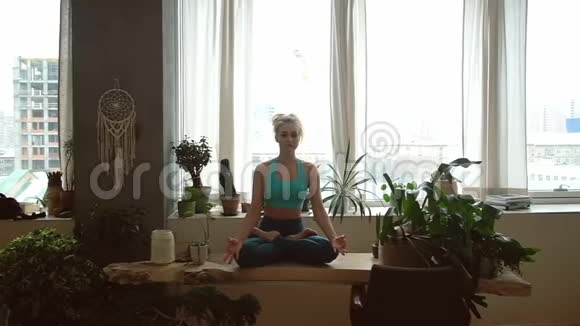 年轻漂亮的女人在家里练习瑜伽室内客房视频的预览图