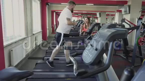 人在健身房跑步机上跑步减肥训练从个人教练为胖子健康和健身演习和视频的预览图