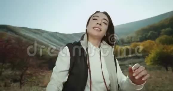 山顶上一个长着漂亮牙齿的漂亮女孩拍了一段自拍视频展示了风景视频的预览图