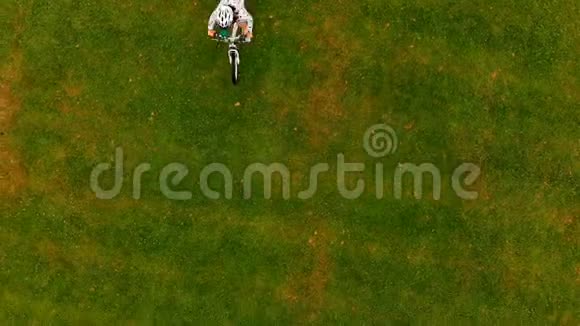 女子在草地上骑自行车视频的预览图