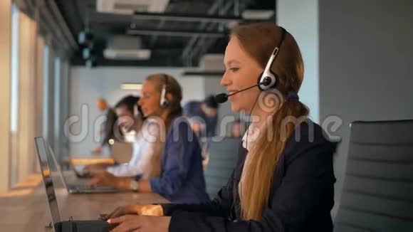 在呼叫中心工作的带耳机的女接线员视频的预览图