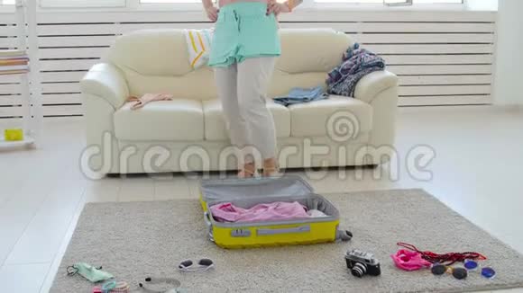 旅游度假理念年轻漂亮的女人把衣服放在手提箱里回家度假视频的预览图