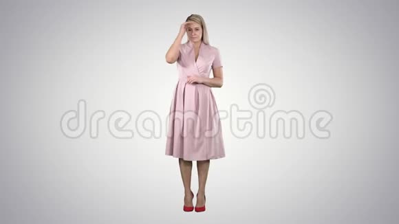 美丽的温柔女孩穿着粉红色的裙子在渐变的背景上看着镜子视频的预览图
