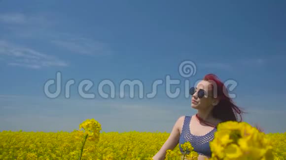 年轻女子穿着波霍式的衣服在绿油油的麦田中摇曳正迎风招展闭着眼睛看着视频的预览图