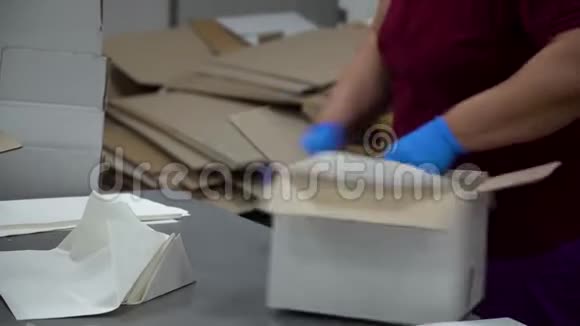 一位工厂女工把纸放在空盒子的中间放在传送带上视频的预览图