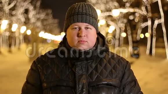 冬天寒冷的夜晚胖子在户外展示了一幅OK标志的肖像视频的预览图