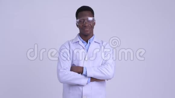 年轻快乐的非洲男子医生戴着防护眼镜双臂交叉微笑视频的预览图