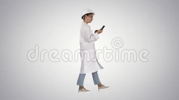 在渐变背景下使用智能手机行走的女科学家视频的预览图
