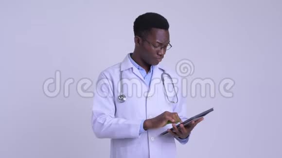 年轻快乐的非洲男医生用数码平板电脑思考视频的预览图