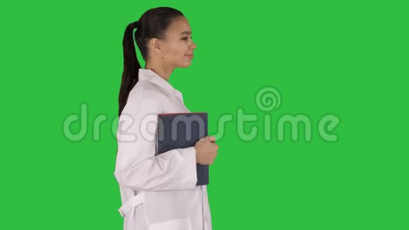 快乐微笑的女医生走着拿着笔记本或文件在绿色屏幕上Chroma键视频的预览图