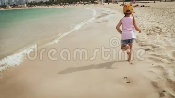 一个可爱的女孩在海滩上奔跑视频的预览图