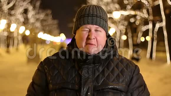 冬天寒冷的夜晚胖子在户外眨眼微笑的画像视频的预览图