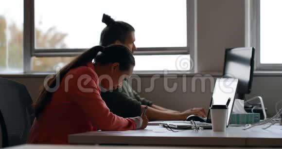 商务同事使用笔记本电脑在办公桌上写日记视频的预览图