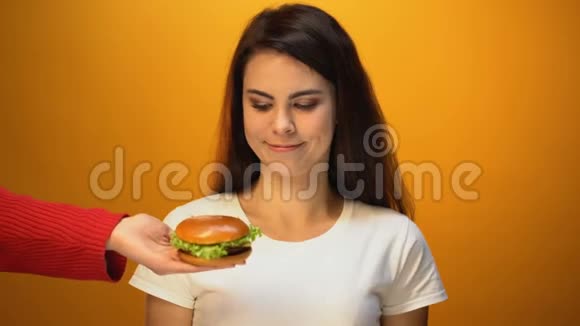 饥饿的女孩选择汉堡包而不是沙拉便宜的垃圾食品和健康的饮食视频的预览图