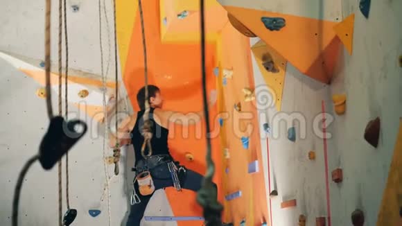一个人爬在一个中心的橙色墙上靠近视频的预览图