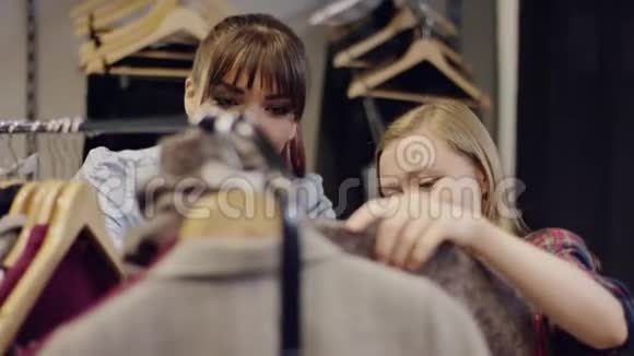 两个年轻漂亮的快乐女人在服装店里寻找新衣服视频的预览图