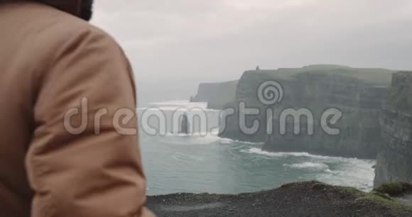 年轻人游客欣赏悬崖和海洋的景观在爱尔兰这个国家最吸引人的地方视频的预览图