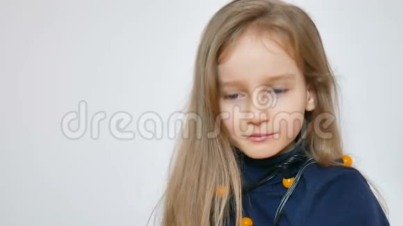 印第安人的肖像画可爱的小女孩留着长长的金发和蓝色的大眼睛戴着一束黄色的圣诞灯视频的预览图