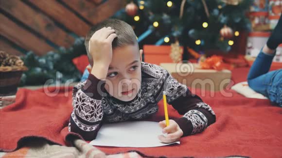 快乐的孩子穿着针织驯鹿毛衣用圣诞礼物清单密封信封送给圣诞老人视频的预览图
