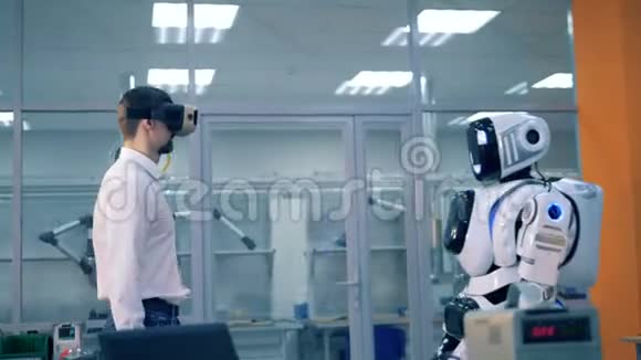 一个人类和一个类似人类的机器人正在握手和观看虚拟现实视频的预览图