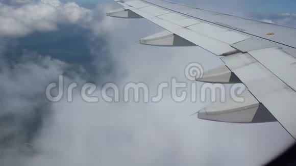 从机翼和云层上的飞机窗口观看去其他国家旅行视频的预览图