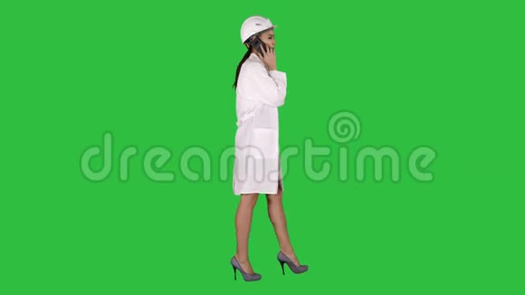 女科学工程师在绿色屏幕上行走时打电话Chroma键视频的预览图
