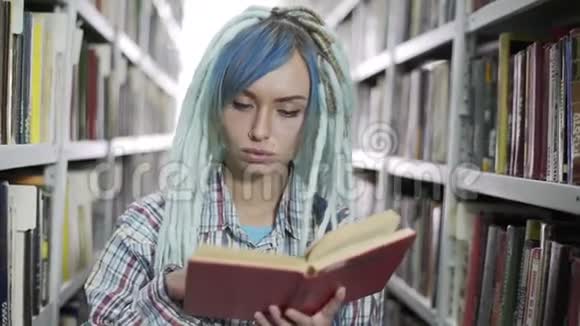 年轻开朗的时髦女人带着可怕的家伙在图书馆的镜头前看书视频的预览图