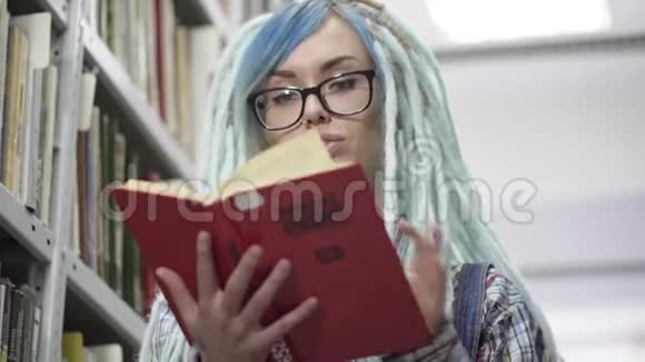 图书馆阅读红色书籍的时髦女性画像视频的预览图