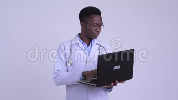 年轻快乐的非洲医生在用笔记本电脑思考视频的预览图