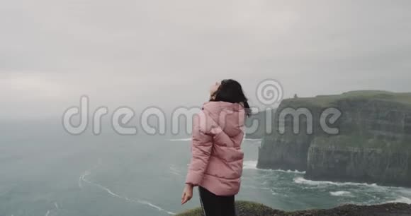 这位女士很佩服她来到悬崖顶的地方她激发了新鲜的空气感觉很棒很棒视频的预览图