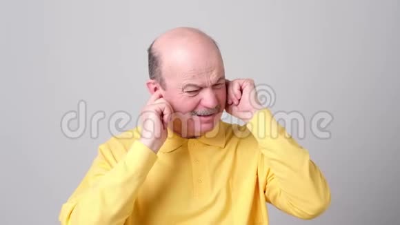 压力大的老人用手指插入耳朵不理会大声喧哗或音乐视频的预览图