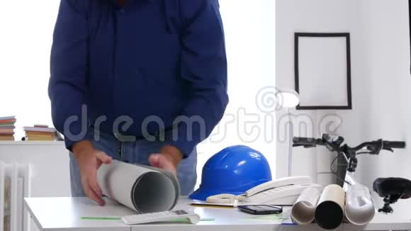疲惫的工程师完成了迟到的工作带上头盔离开建筑师办公室视频的预览图
