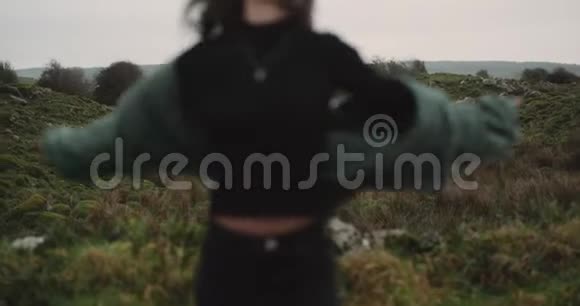在农村绿茵场的中央美丽的年轻女子在镜头前热情地移动4k视频的预览图