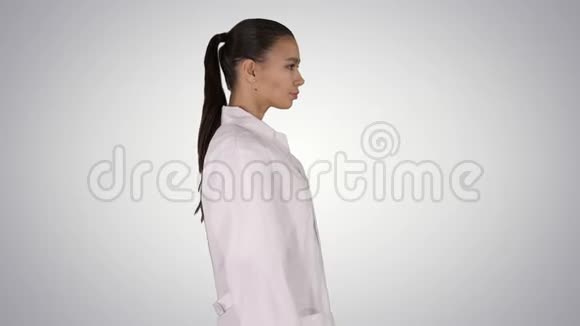医生美容师穿着白色长袍走在渐变的背景上视频的预览图