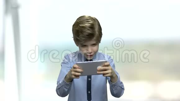 快乐的男孩在他的智能手机上玩游戏视频的预览图