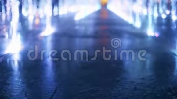 美丽的年轻女子穿着连衣裙在傍晚的灯光喷泉里散步动作缓慢视频的预览图