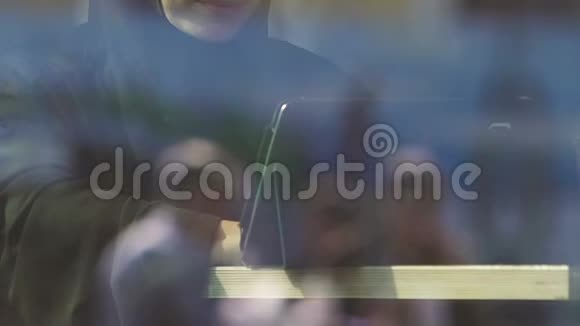 戴眼镜的穆斯林妇女在咖啡馆里用平板电脑在线学习技术视频的预览图