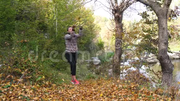 女性在大自然中投掷树叶动作缓慢视频的预览图