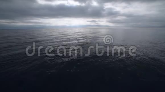 蓝色海面上乌云密布的灰色天空视频的预览图