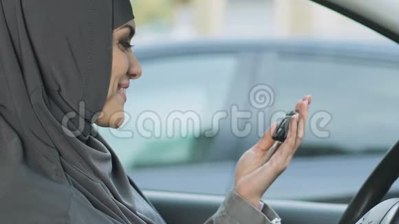 持有钥匙的穆斯林幸福妇女伊斯兰女性司机的权利购买汽车视频的预览图