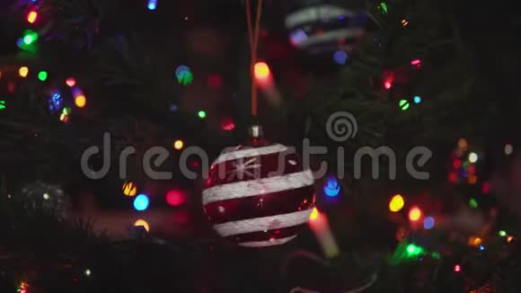 带有雪花和条纹的红色圣诞球在树枝上旋转视频的预览图