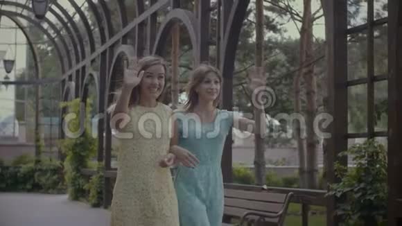 两个快乐的女人在公园和朋友打招呼视频的预览图