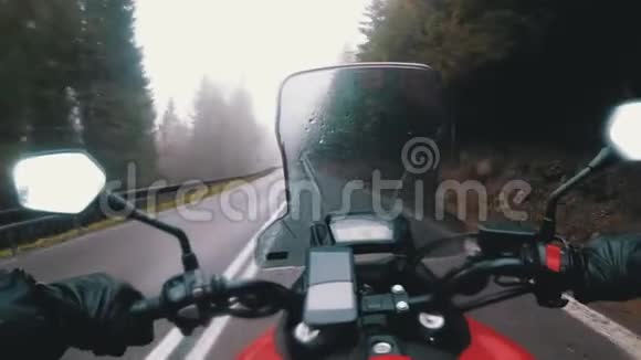 摩托车手在恶劣的天气风暴雨和雾中骑在山路上POV视频的预览图