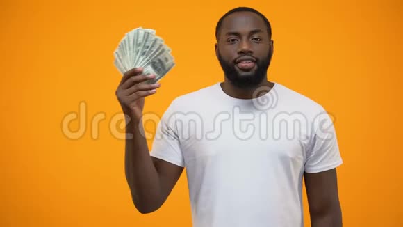 非裔美国人拿着一大堆钱竖起大拇指创业视频的预览图