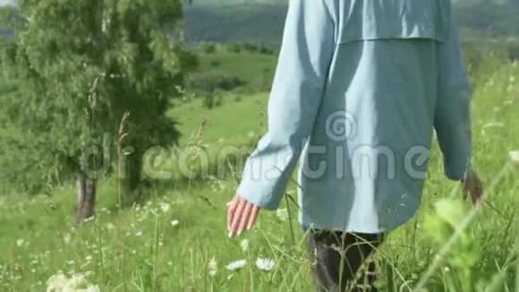 一个女人带着花在绿地上散步视频的预览图