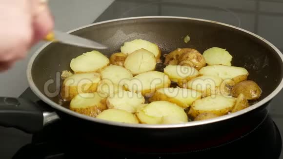 快关门用黄油炒的平底锅里的土豆一个女人用刀子把碎片翻过来食物概念视频的预览图