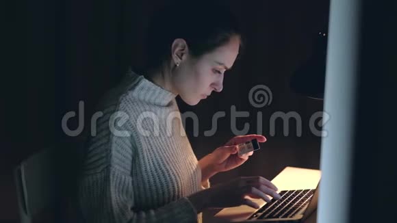 美丽的高加索女人使用笔记本电脑通过信用卡购买网上购物视频的预览图